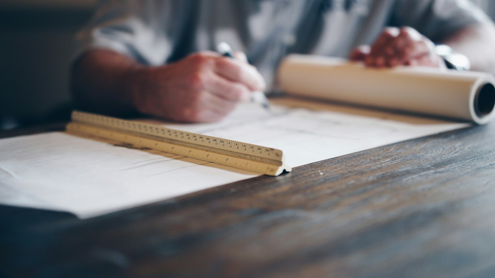 An architect sketching building plans at a drawing table
